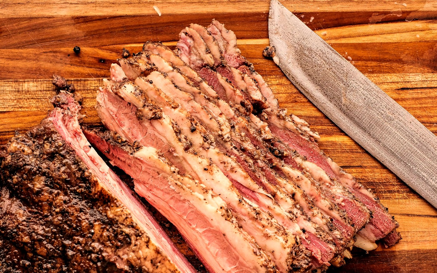 Sliced smoked brisket with dark bark on a cutting board