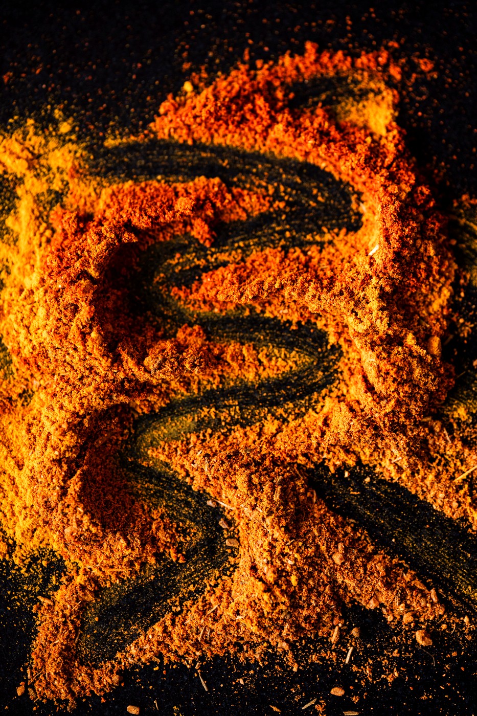 Spilled spice art on a black surface