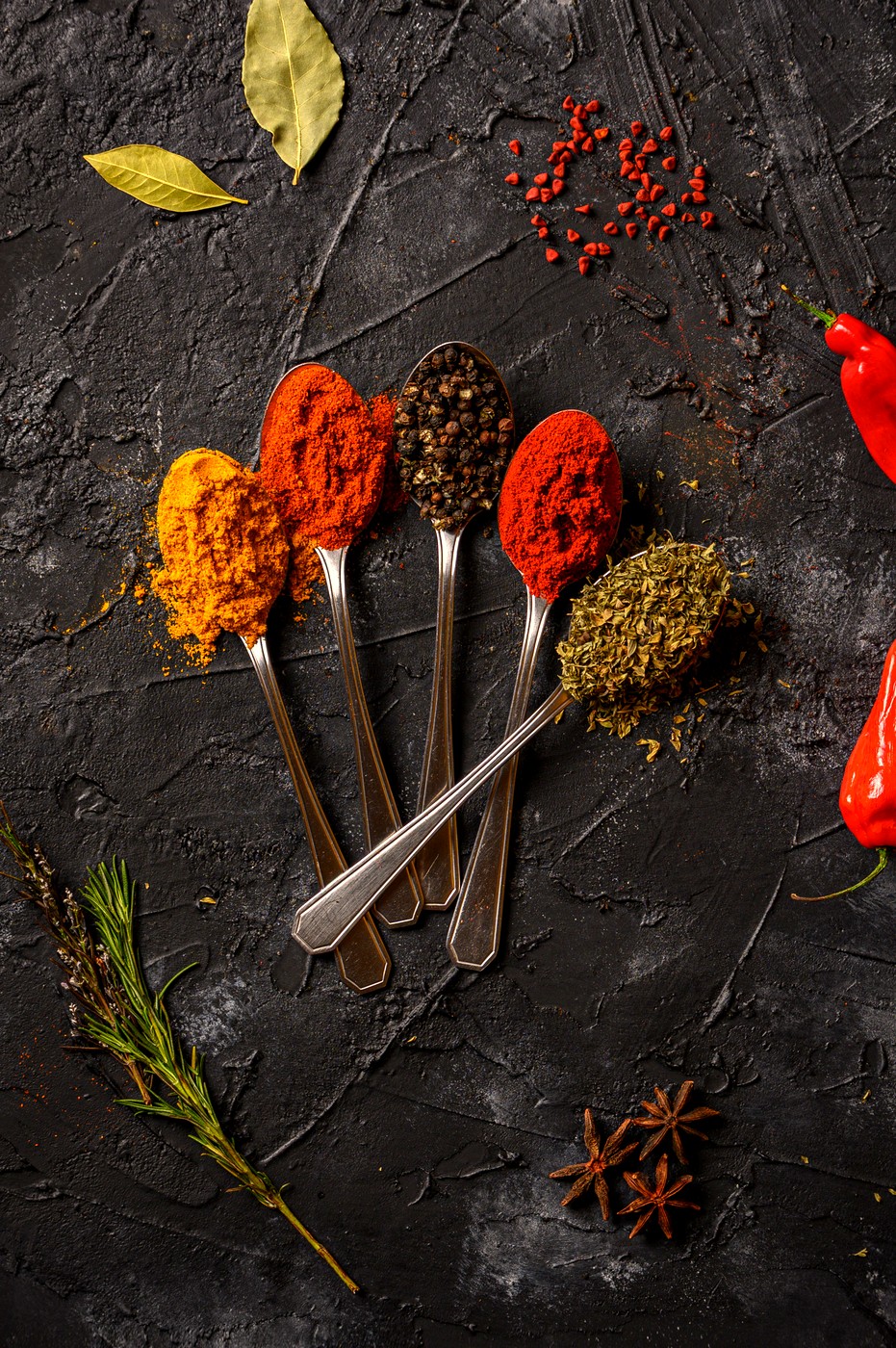 Spice spoons on dark slate